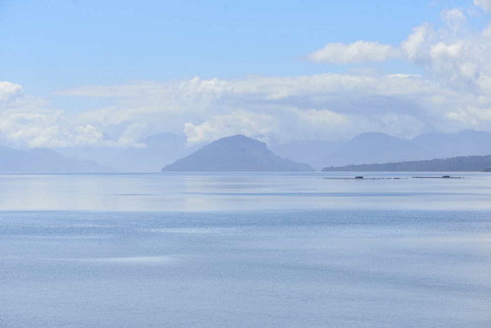 blue sea near mountain under blue sky during daytime