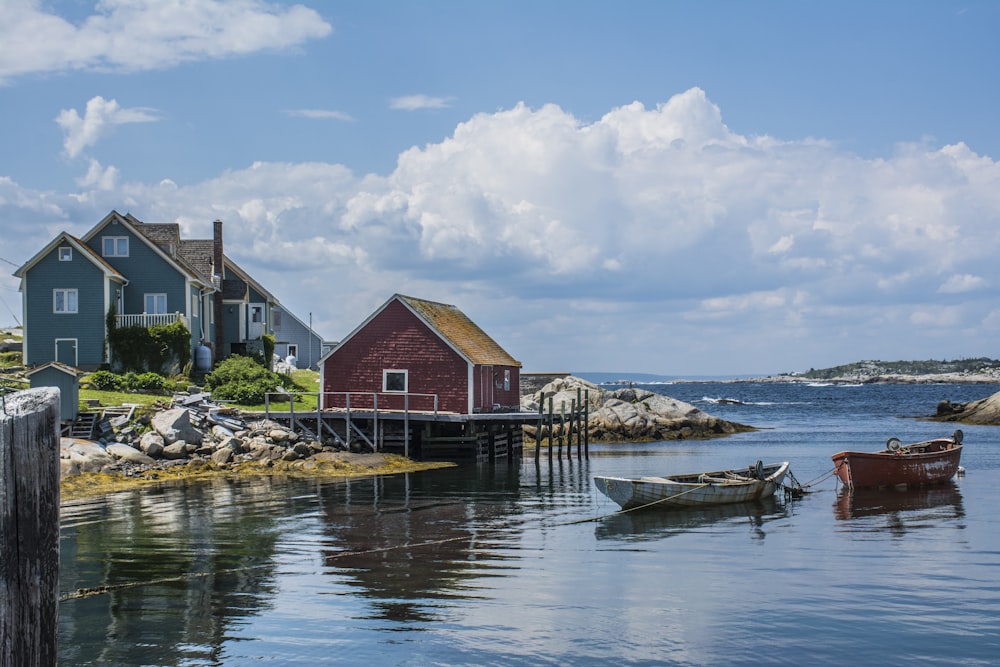 brown wooden house beside body of water under blue sky during daytime