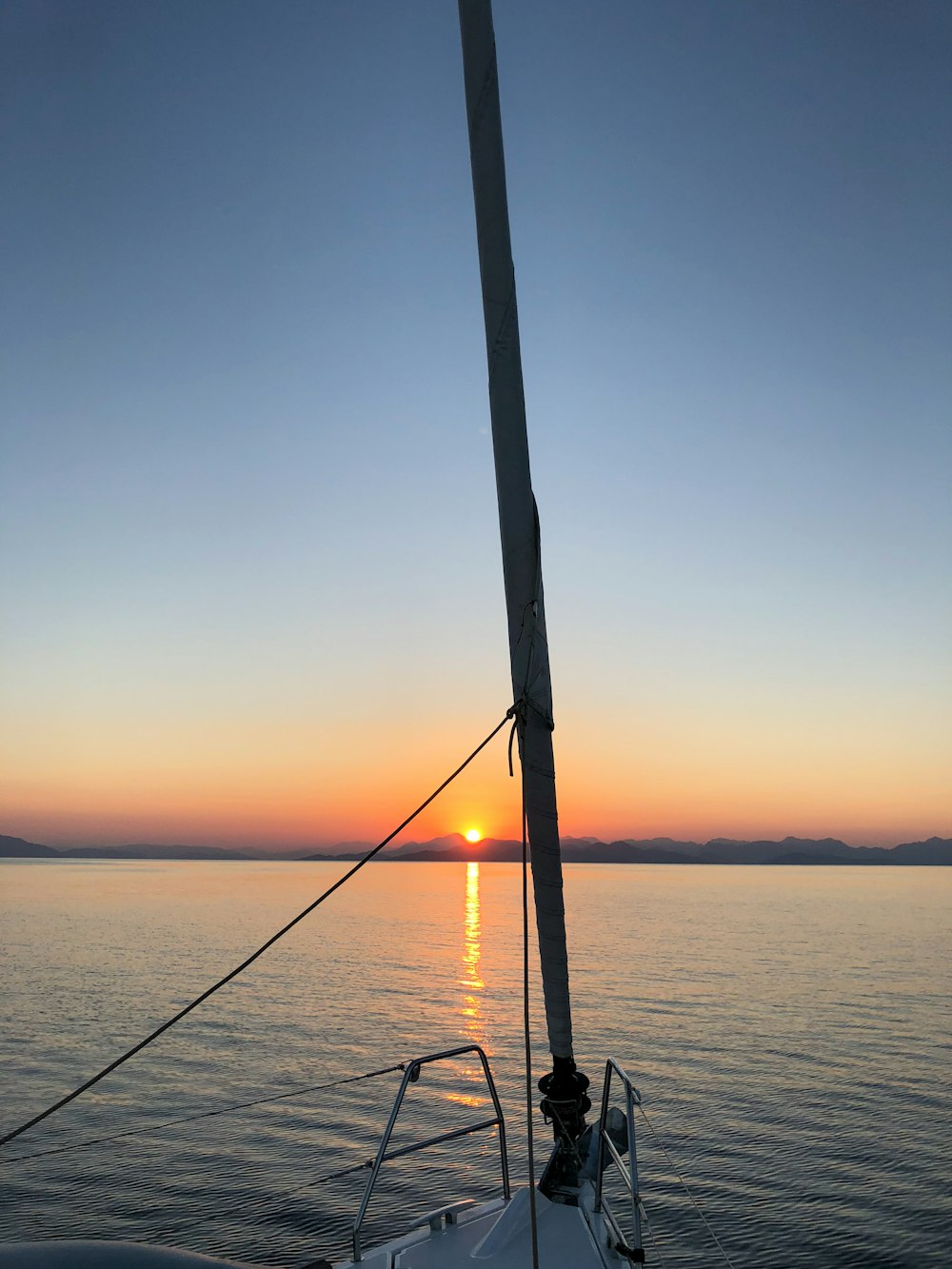 Silhouette einer Person, die bei Sonnenuntergang auf See fischt