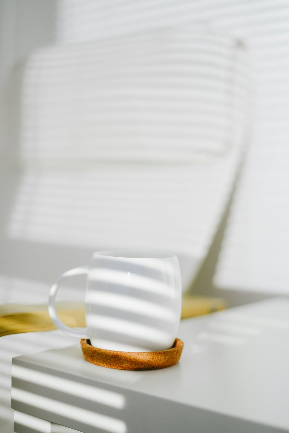 white ceramic mug with brown and white pastry on white ceramic plate