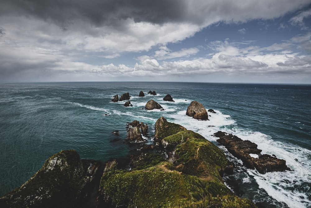 rocky shore under cloudy sky during daytime