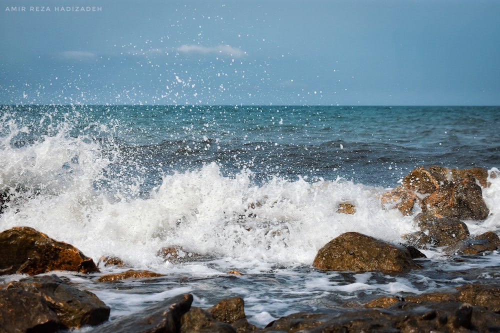 ocean waves crashing on rocks during daytime