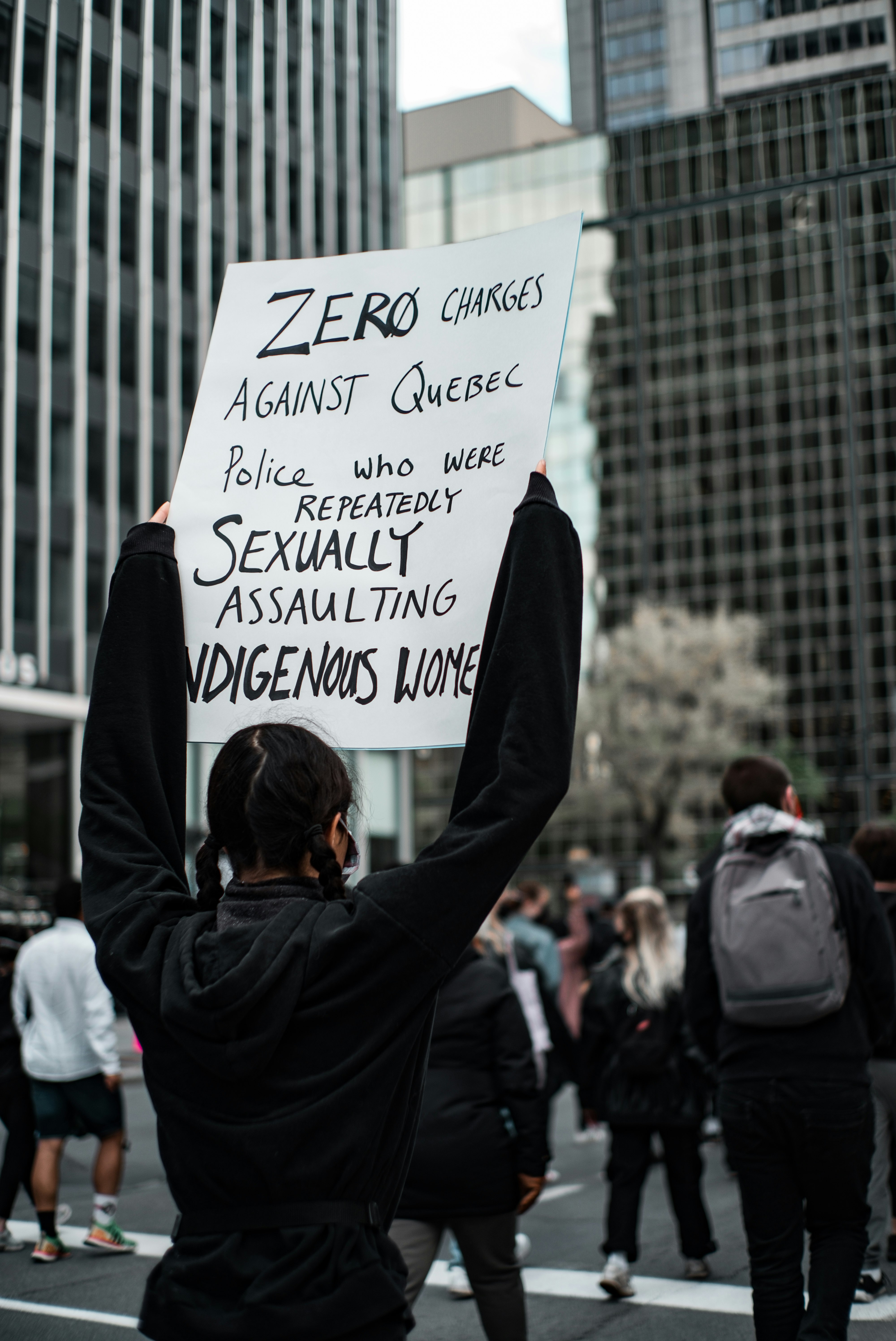 man in black jacket holding white and black quote board during daytime