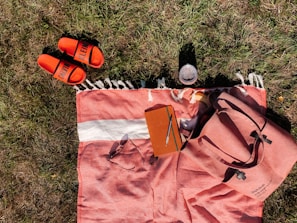 A picnic setup with colorful towels used as blankets on lush green grass