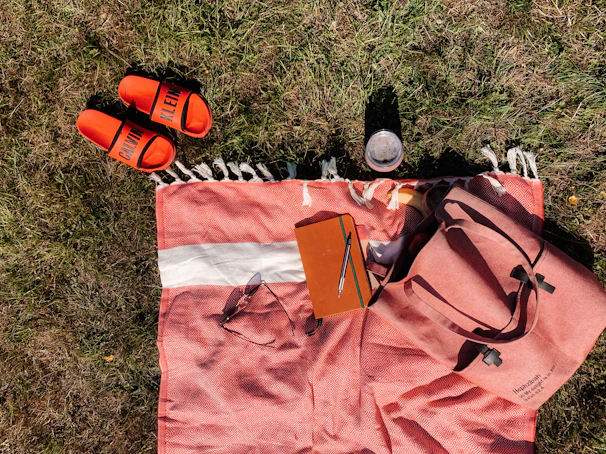 A set of colorful shorts laid out on a grassy picnic blanket with scattered toys around.