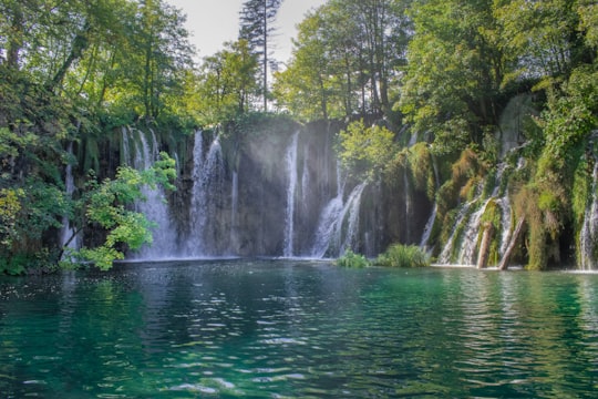 waterfalls in the middle of green trees during daytime in Plitvice Lakes National Park Croatia