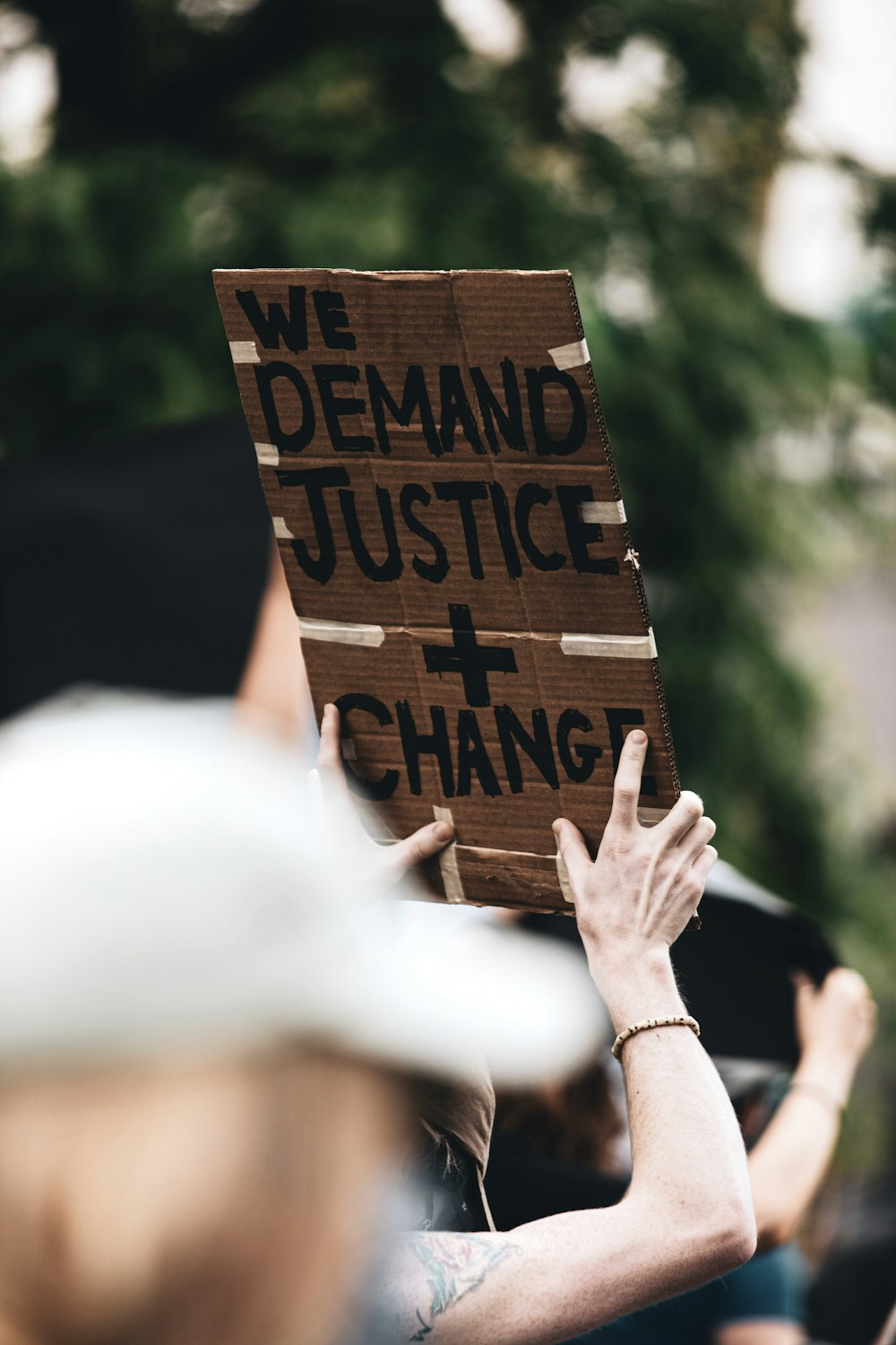 une personne tenant une pancarte qui dit que nous exigeons justice et changement