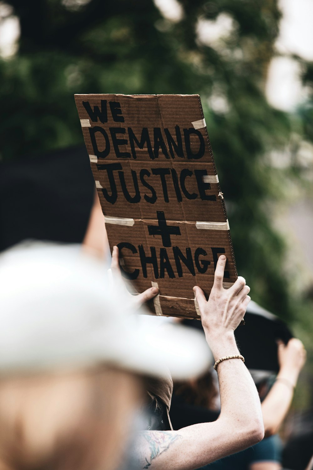 Eine Person, die ein Schild hält, auf dem steht, dass wir Gerechtigkeit und Veränderung fordern