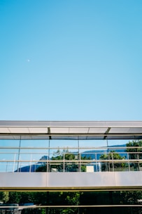 A futuristic office building with glass facades reflecting the Colorado mountains.