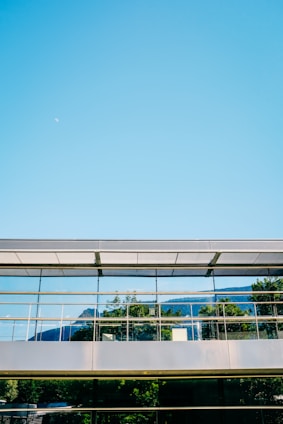 A futuristic office building with glass facades reflecting the Colorado mountains.