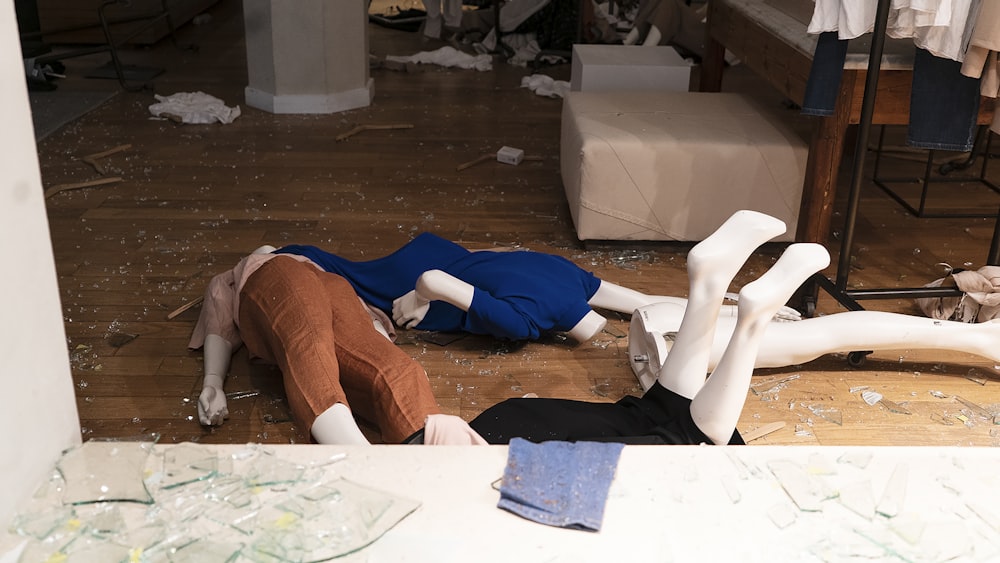 woman in blue shirt and brown pants lying on floor