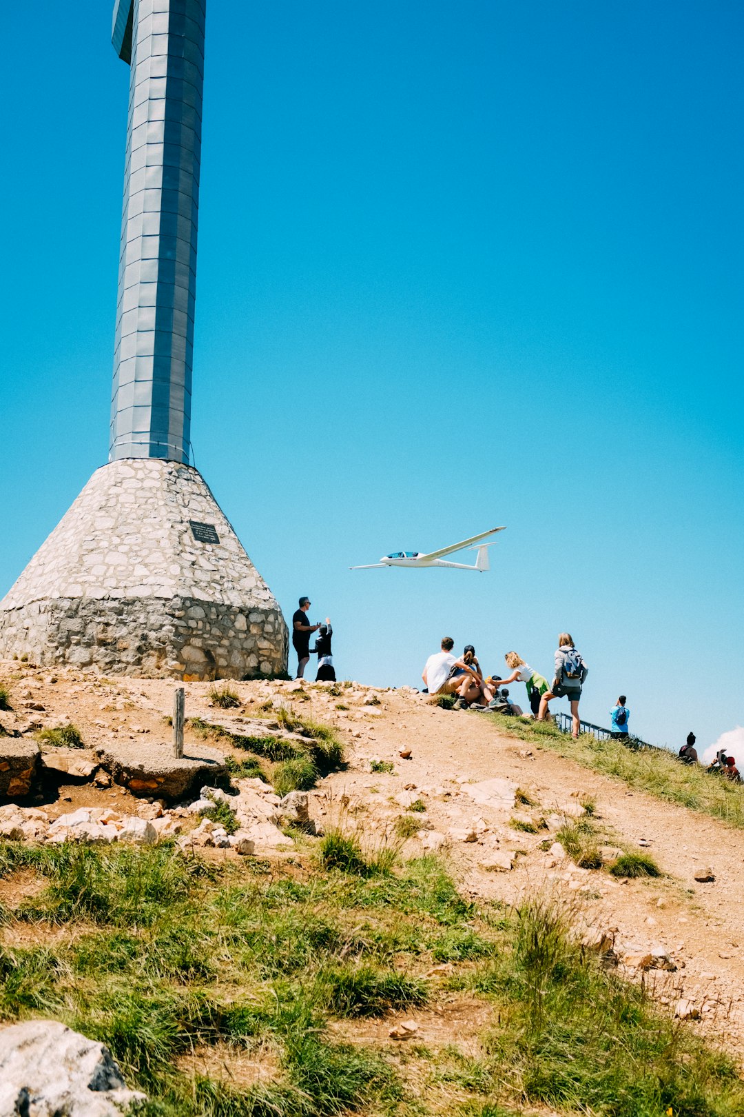 people standing on brown rock formation under blue sky during daytime