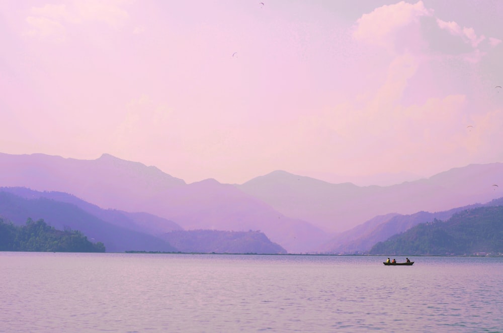 silhouette of person riding boat on lake during daytime