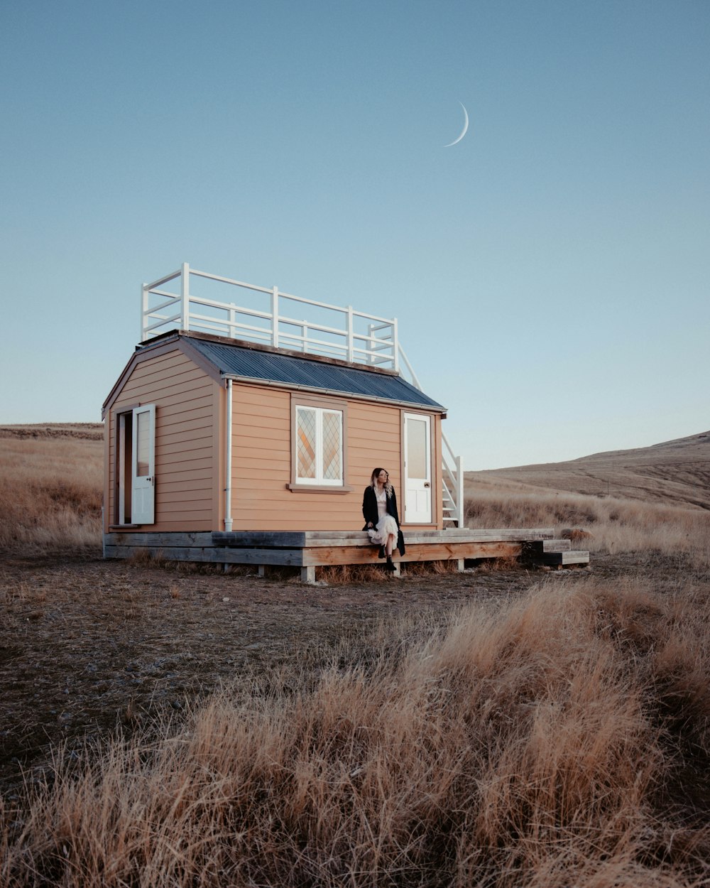 Maison en bois blanc sur un champ d’herbe brune pendant la journée