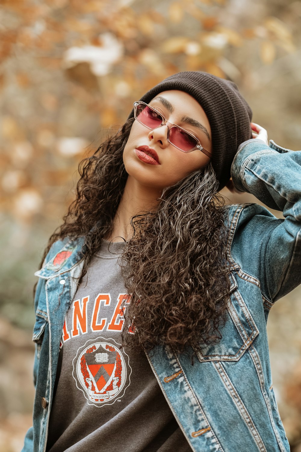 woman in blue denim jacket wearing black knit cap and black framed sunglasses