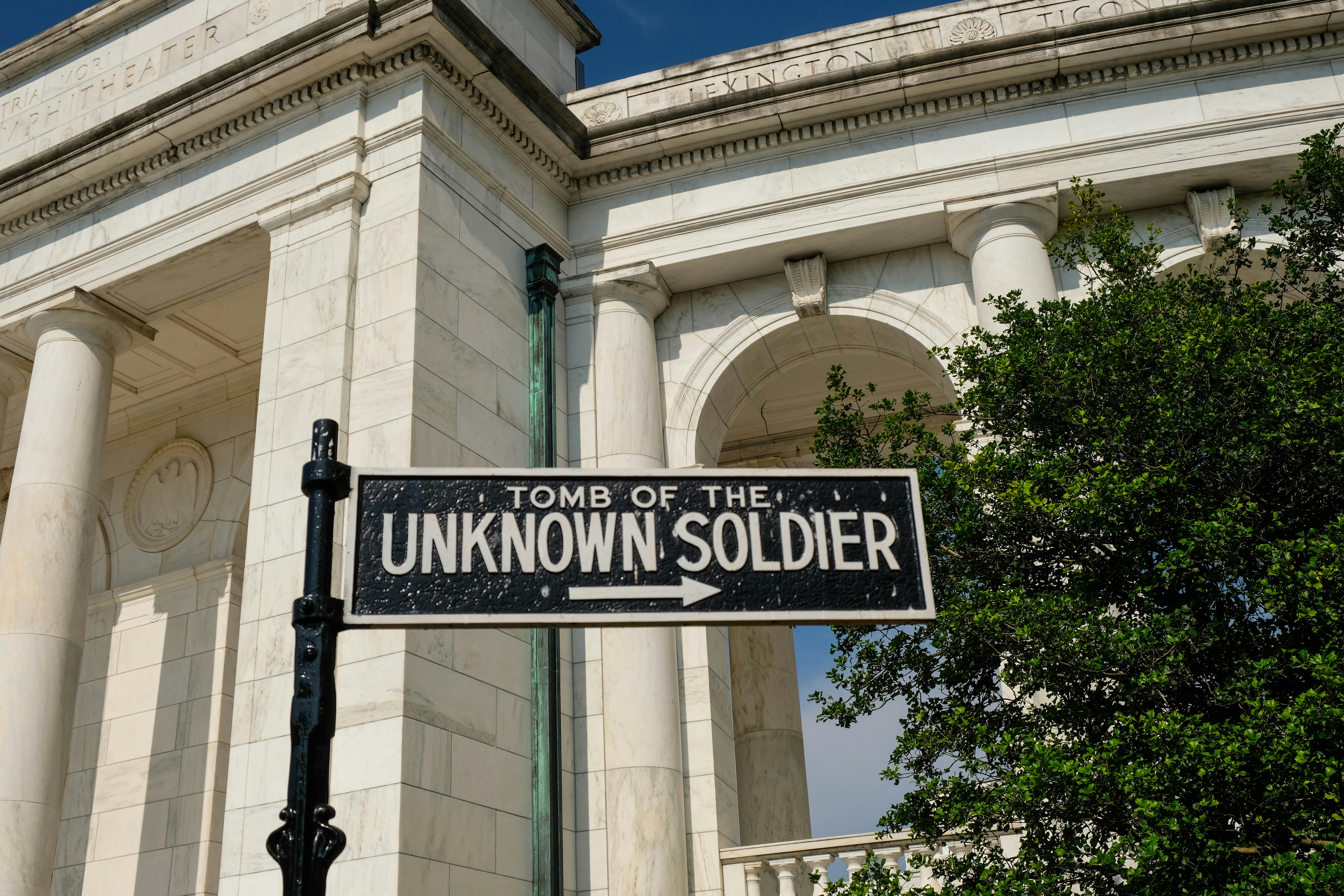 A sign pointing which way to walk around the coliseum at the Arlington National Cemetery where you'll find the Tomb of the Unknown Soldier. - Arlington, VA - Sara Cottle
