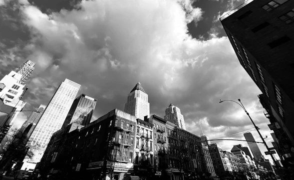 A striking cityscape showing a mix of old and new architecture under a dramatic sky.