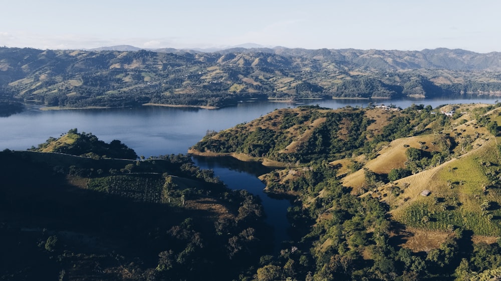 aerial view of green and brown mountains and lake