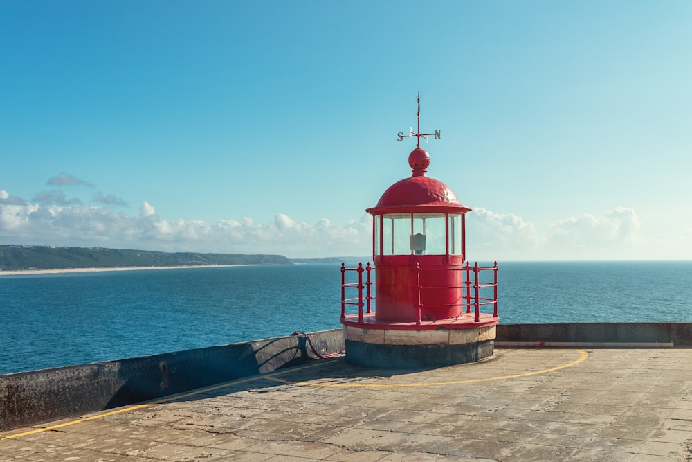 red and white wooden house near sea under blue sky during daytime