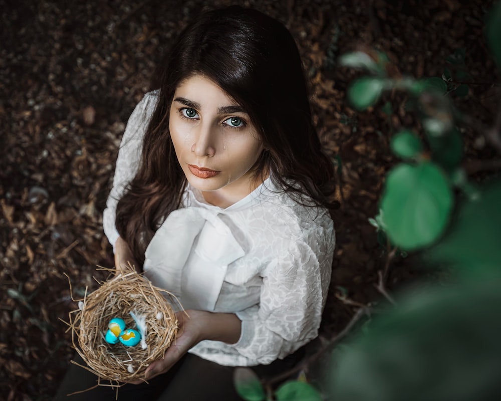 woman in white dress holding brown basket