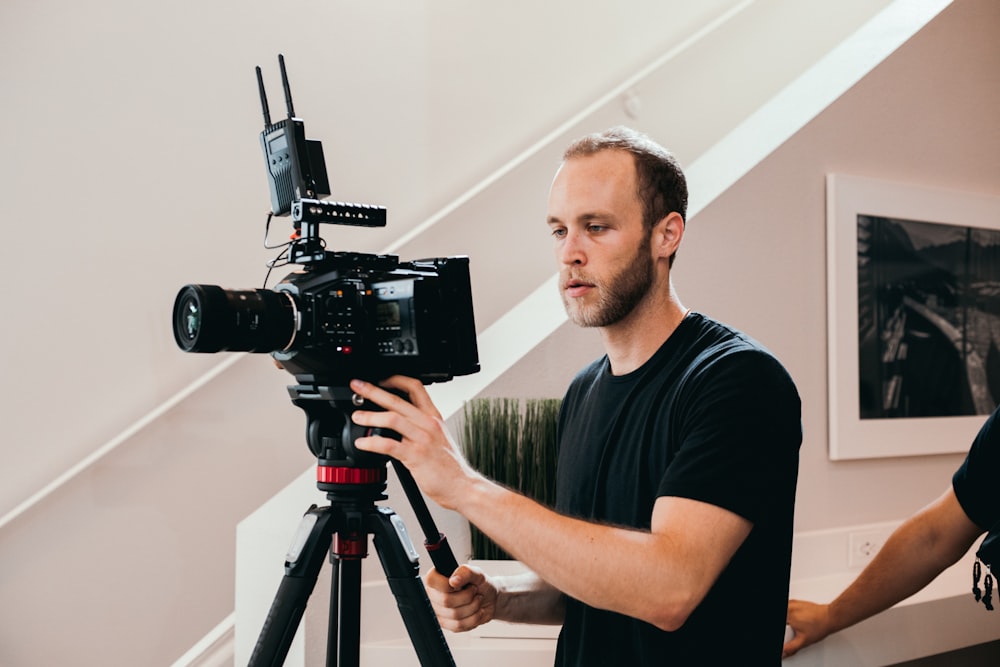 man in black crew neck t-shirt holding black video camera