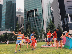Kids enjoying lively urban summer camp games in a bright park setting.