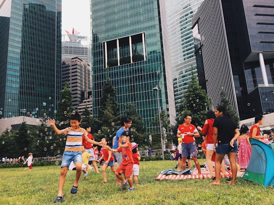 A lively group of diverse people playing dodgebee outdoors in a vibrant urban park setting.
