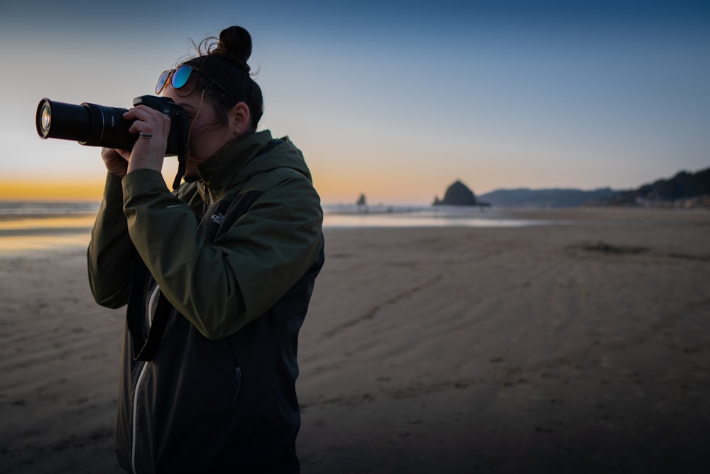 man in gray hoodie taking photo of sea during daytime