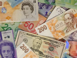 Euro banknotes spread out alongside Thai baht notes, highlighting global currencies.