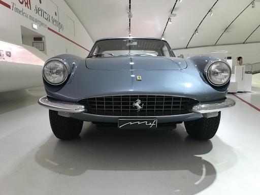 A sleek navy blue and electric blue themed office reception area with a car restoration poster on the wall.