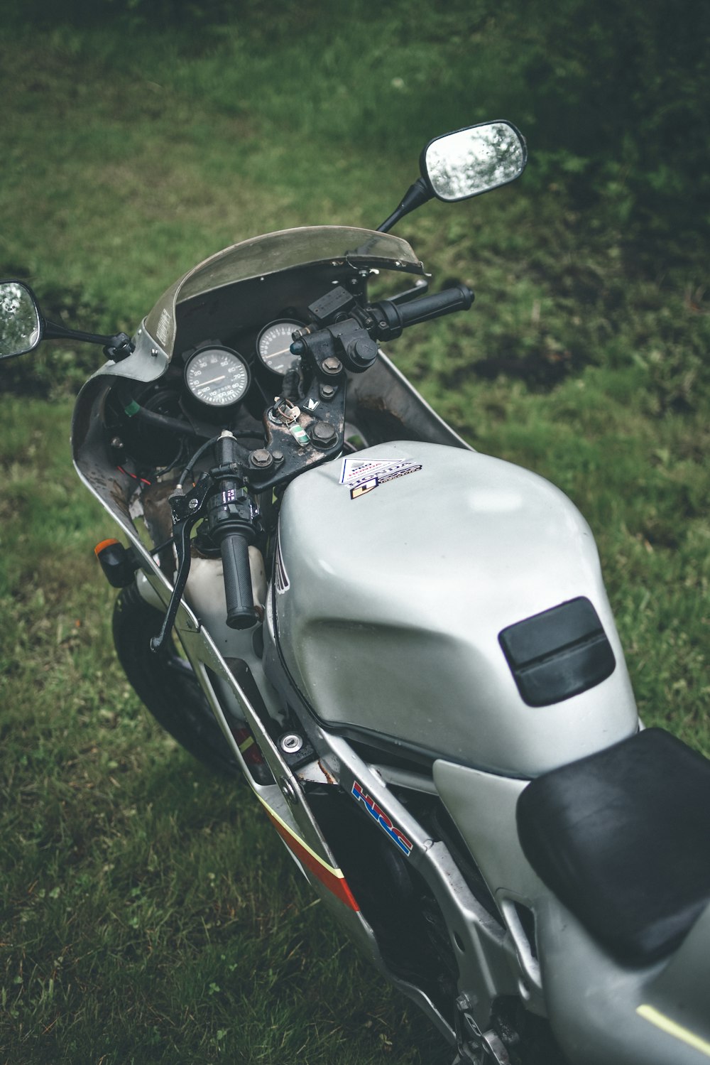 white and black motorcycle on green grass field during daytime