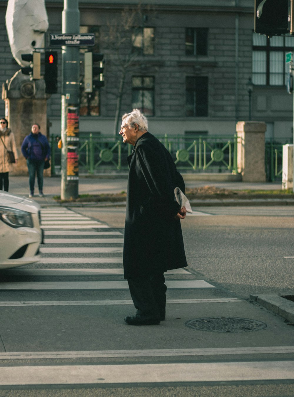 woman in black abaya standing on pedestrian lane during daytime