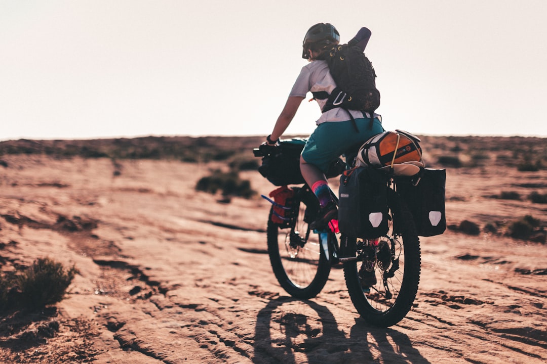 man in black shirt riding on black mountain bike during daytime