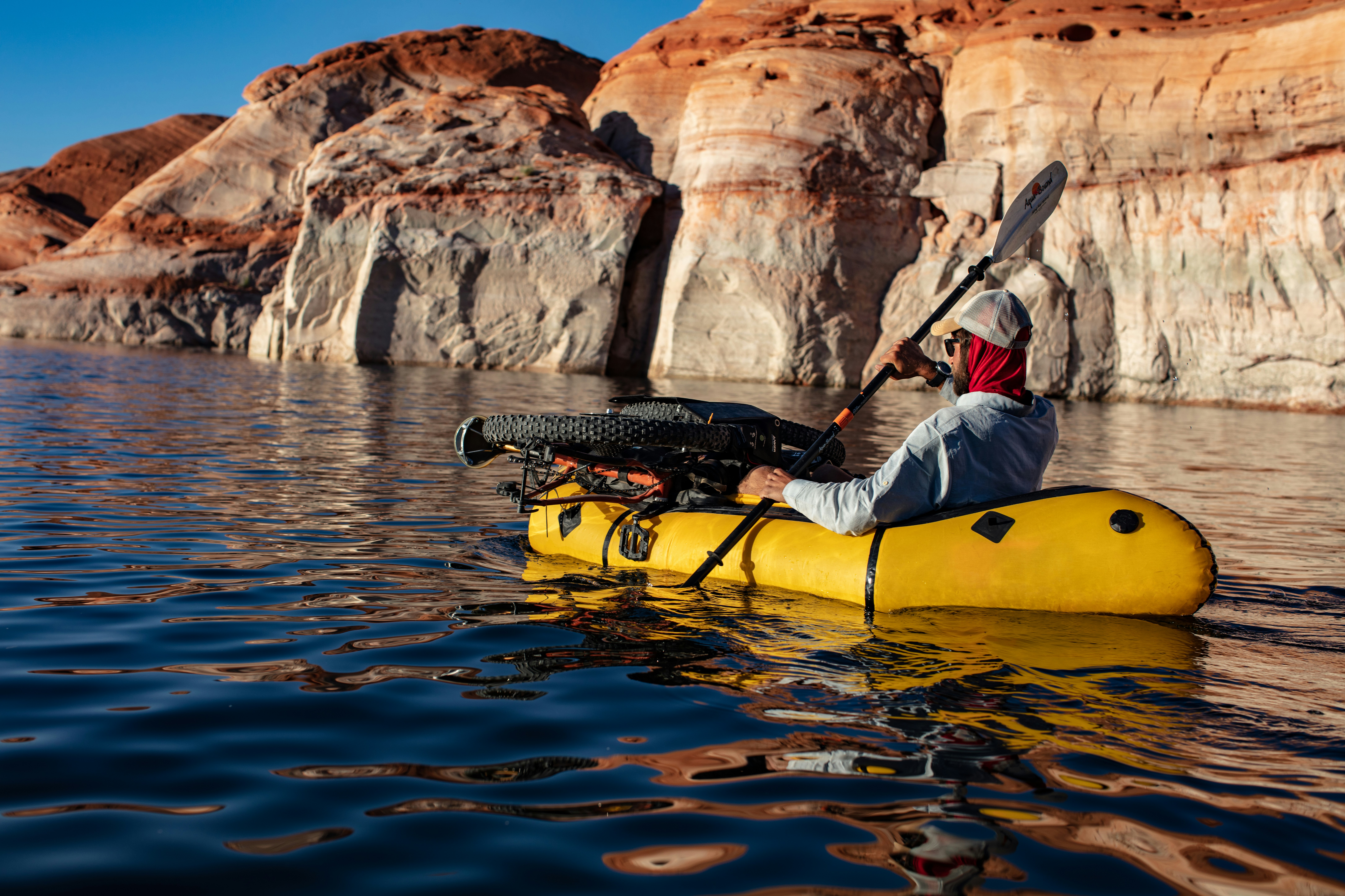 Man in blue jacket and blue denim jeans riding yellow kayak on river during daytime photo Free