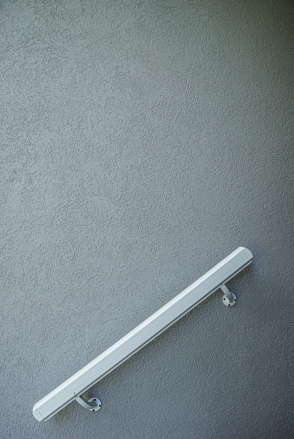 white metal pipe mounted on blue wall