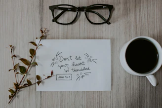 black framed eyeglasses on white printer paper