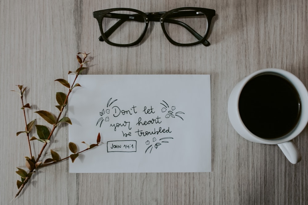 black framed eyeglasses on white printer paper