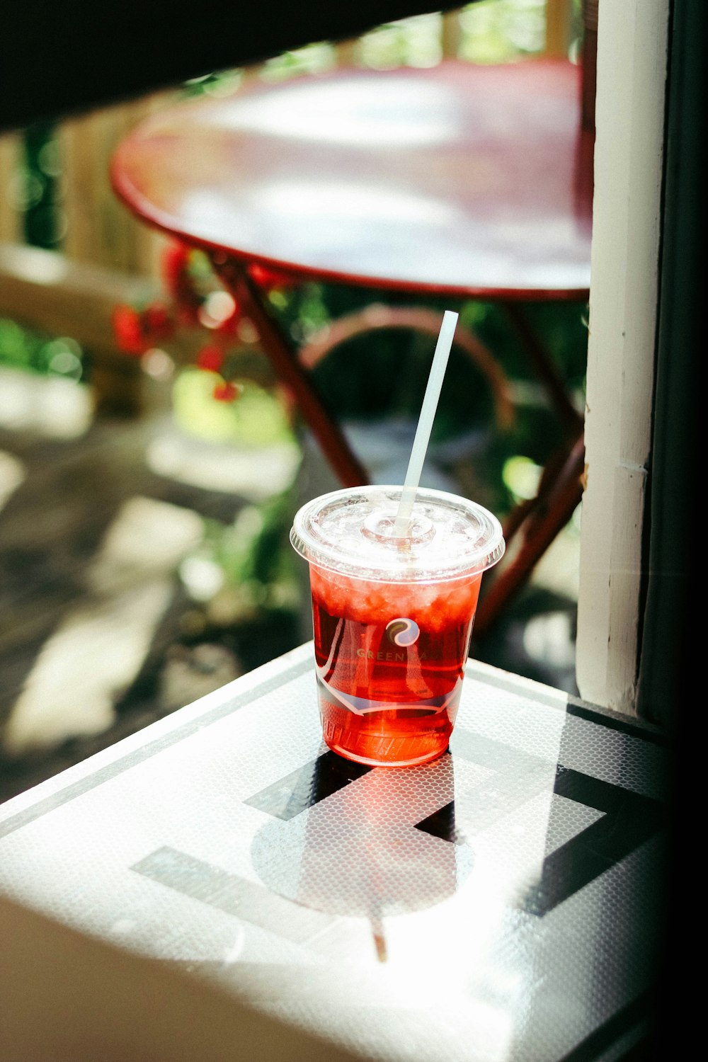 clear plastic cup with red liquid on table