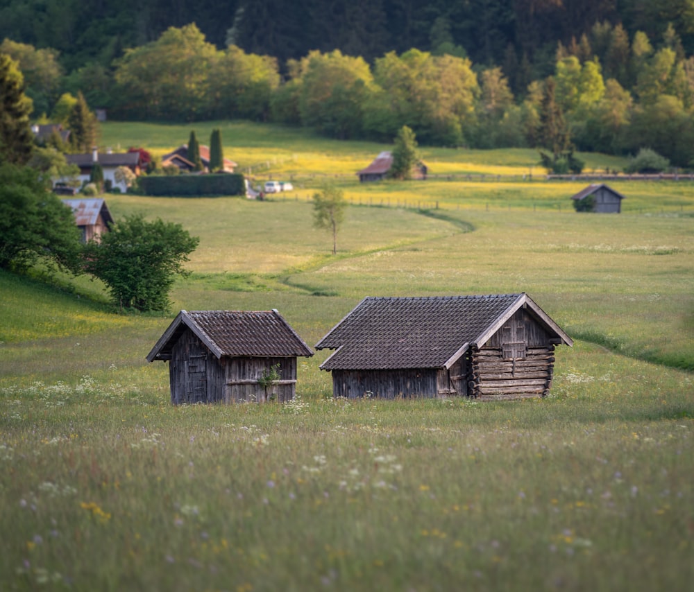 brown wooden house on green grass field during daytime