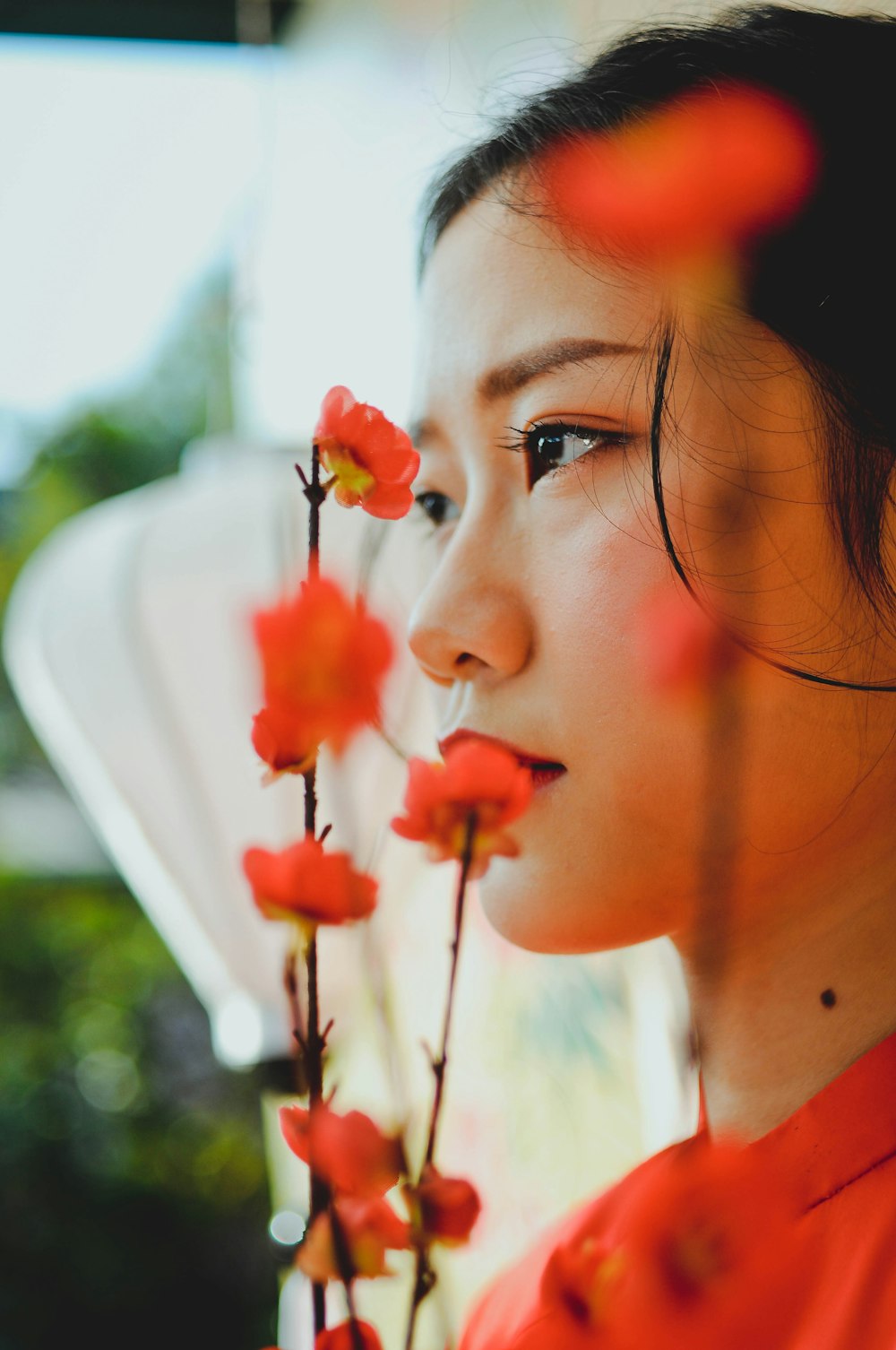 woman with red flower on her ear