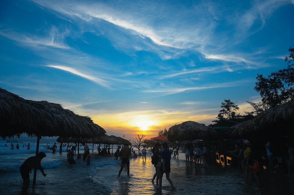 people walking on beach during sunset