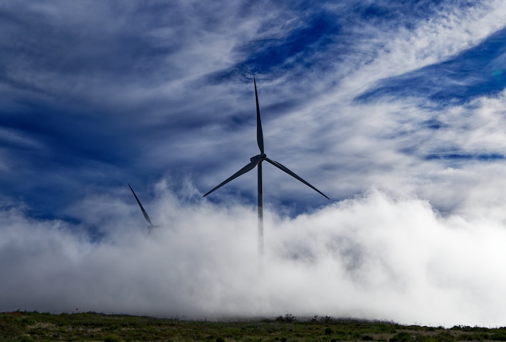 wind turbine on green grass field under white clouds