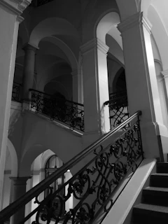 Elegant monochrome shot of a grand staircase featuring bespoke railings and polished surfaces.