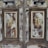 An antique wooden door with ornate floral decorations is prominently featured. The surface is weathered, showcasing a patina of faded paint and exposed wood grain. The floral motifs are delicately painted, with clusters of roses and greenery, adding a vintage charm to the doors.