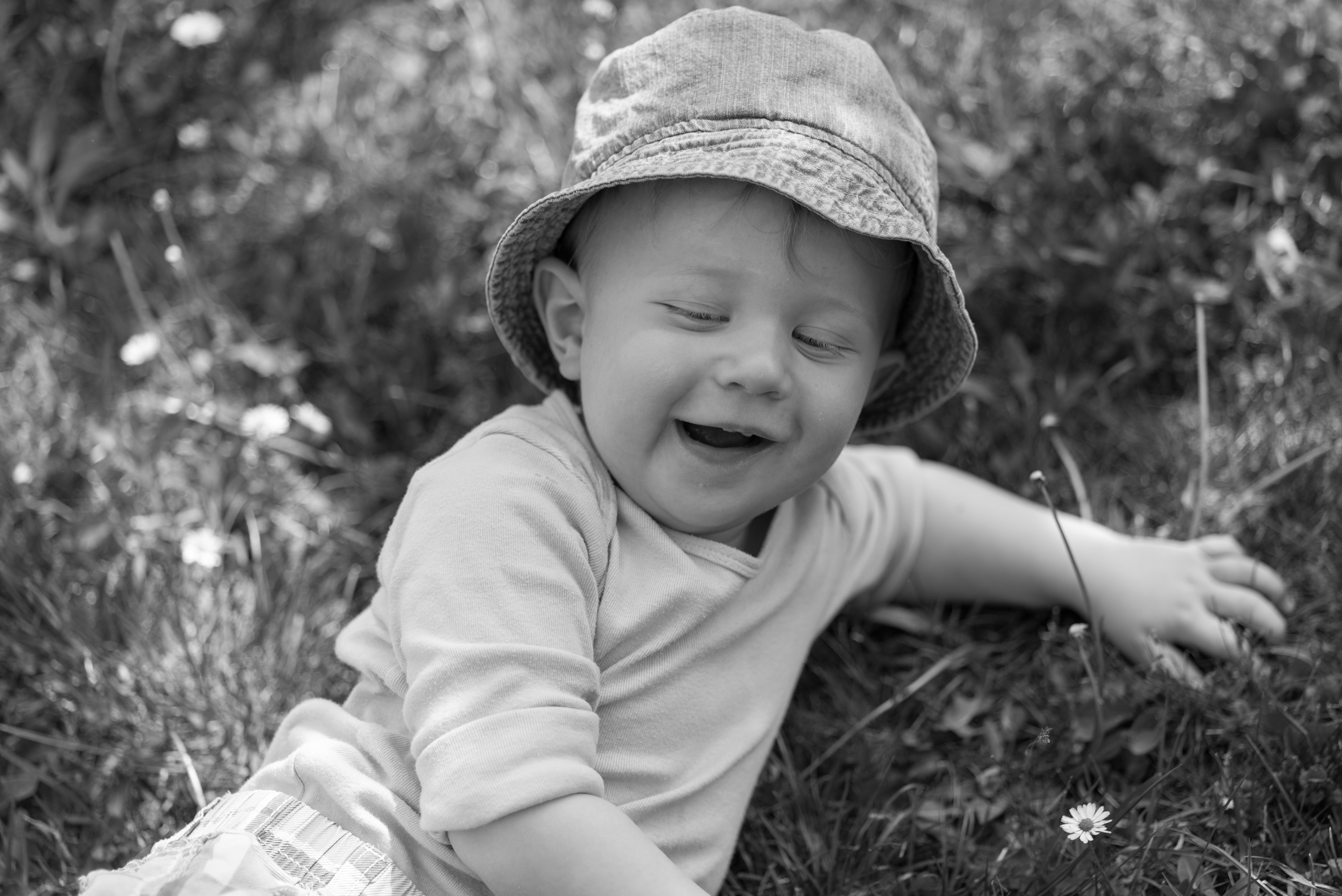 Grayscale photo of a child wearing a hat and t-shirt