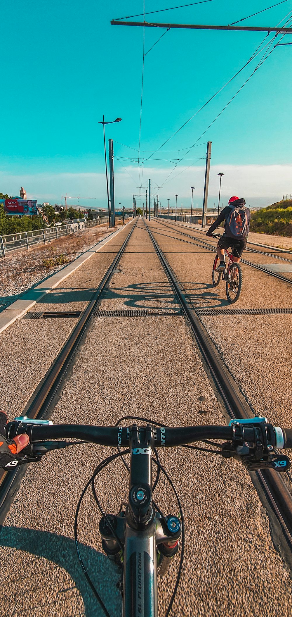 man in black jacket riding bicycle on train rail during daytime