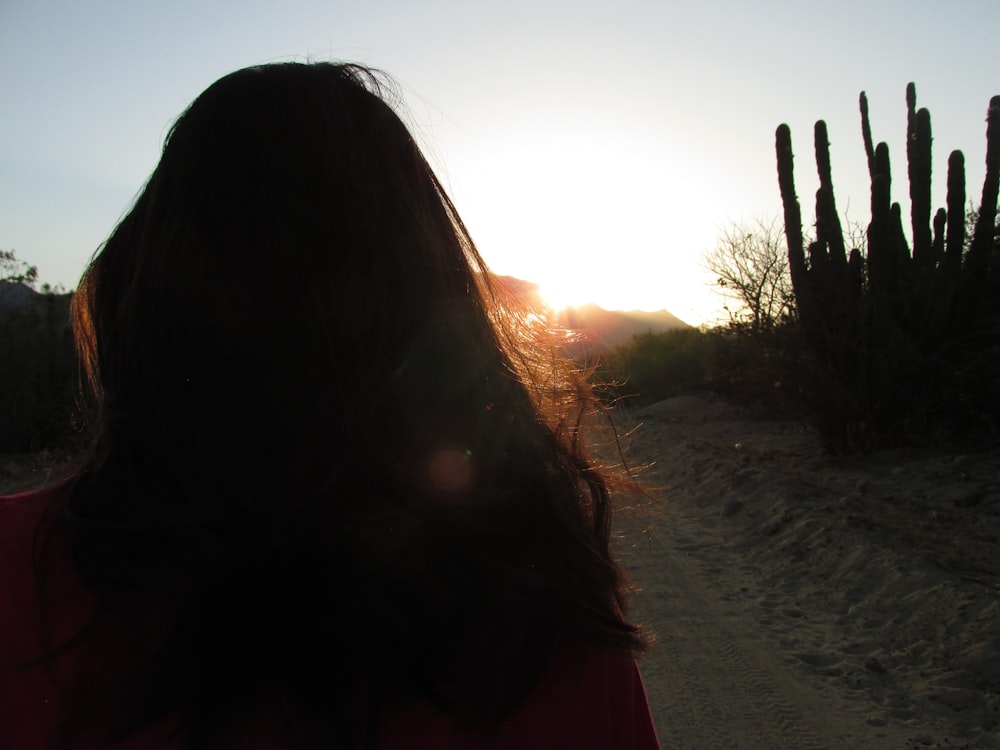 woman in red shirt standing on sand during daytime