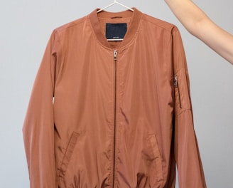 brown long sleeve shirt on white clothes hanger
