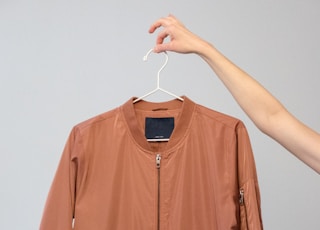 brown long sleeve shirt on white clothes hanger