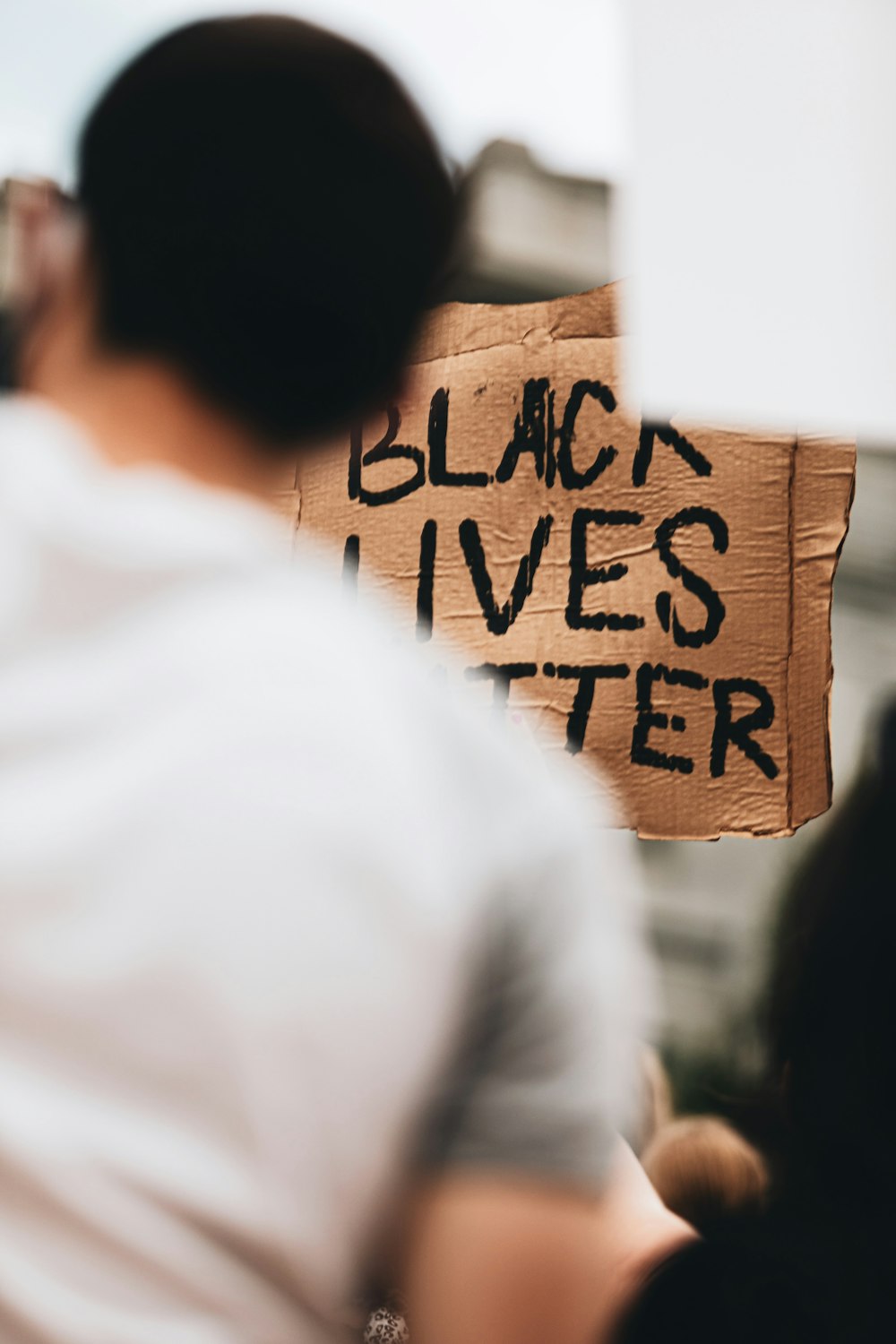 uomo che tiene un cartello Black Lives Matter